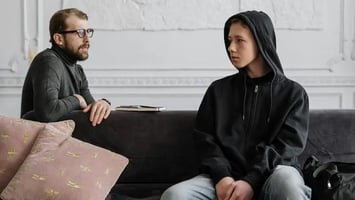 Struggling teen meeting with a therapist.