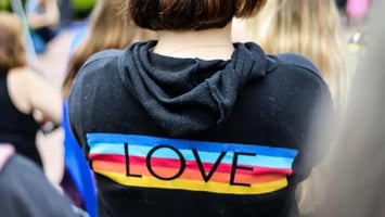 Teen wearing a Love sweater.