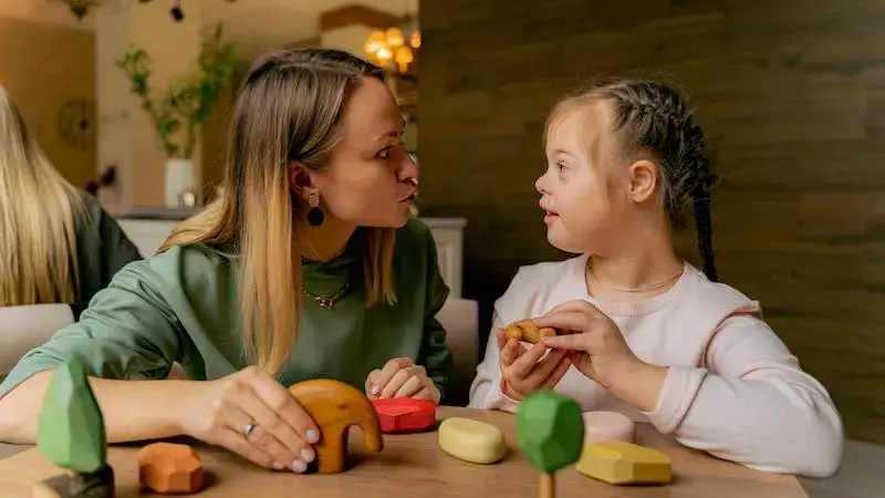 Caregiver playing with a child with an IDD.